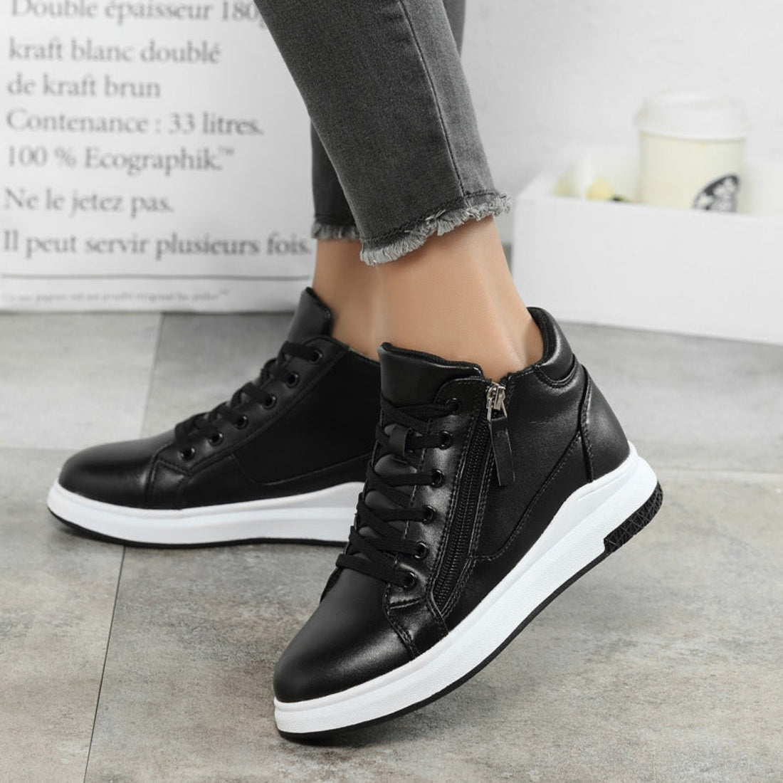Women's Blair Street Luxe High-Top Sneakers in Black shown on foot, featuring sleek black lace-up uppers, ankle-height silhouettes, rounded toes, subtle stitched detailing, and thick contrasting white soles for polished Fall and Winter street-style outfits.