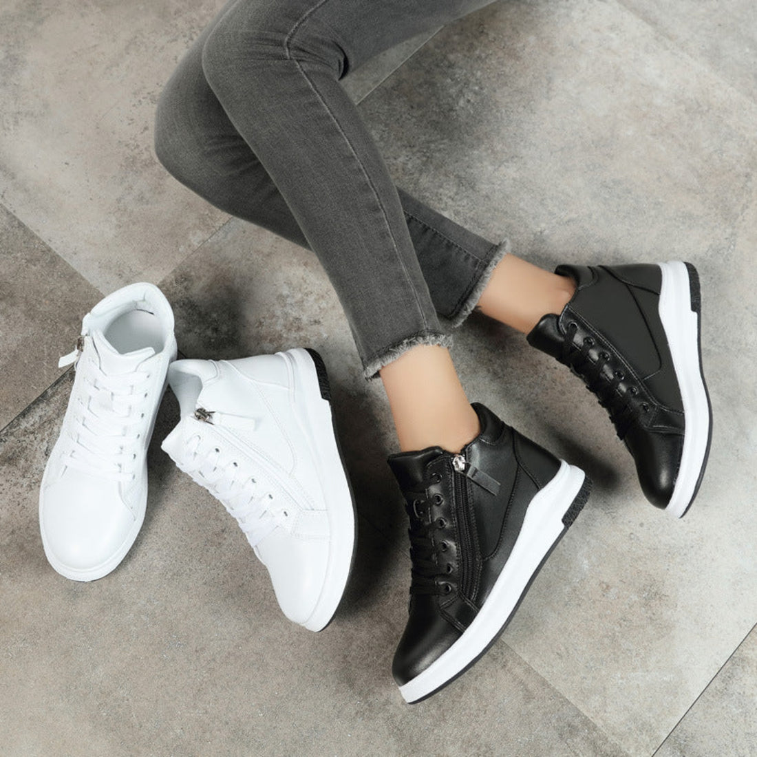 Women's Blair Street Luxe High-Top Sneakers in Black shown on foot, featuring sleek black lace-up uppers, ankle-height silhouettes, rounded toes, subtle stitched detailing, and thick contrasting white soles for polished Fall and Winter street-style outfits.