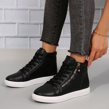 Women’s Brielle Luxe Zip-Wedge High-Top Sneakers in Black shown on foot, featuring a sleek ankle-high silhouette, black lace-up front, textured upper panels, gold-tone side zipper detail, rounded toe, concealed wedge-style lift, and thick contrasting white rubber sole for polished Fall and Winter casual streetwear.