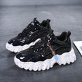 Pair of women's Nova Sparkle Luxe Chunky Sneakers in Black featuring dark layered uppers, subtle glossy and sparkle accents, black lace-up closures, rounded toes, and contrasting chunky white sculpted soles for bold Fall and Winter street-style outfits.