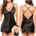 Amara women's classic black satin-look chemise nightdress shown from the front and back on a brunette model, featuring intricate black floral lace cups with scalloped edges, a plunging V-neckline, slender spaghetti shoulder straps, smooth glossy black fabric, and a short flowing hemline. The rear view highlights the low open-back design with thin crisscross straps, while a circular inset provides a closer look at the back strap detailing.