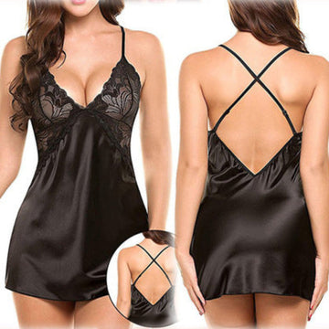 Amara women's classic black satin-look chemise nightdress shown from the front and back on a brunette model, featuring intricate black floral lace cups with scalloped edges, a plunging V-neckline, slender spaghetti shoulder straps, smooth glossy black fabric, and a short flowing hemline. The rear view highlights the low open-back design with thin crisscross straps, while a circular inset provides a closer look at the back strap detailing.
