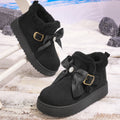 Women’s black Aspen Luxe fleece-lined platform snow boots featuring soft plush lining around the ankle, decorative bow and buckle detailing, rounded toes, and thick platform soles designed for fashionable cold-weather wear.