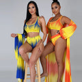 Side-by-side view of two models wearing the Azaria Sunset resort swimwear set in blue-and-yellow and orange-and-yellow combinations, showing the matching cropped swim tops, high-waisted bottoms, and coordinating long flowing cover-ups.