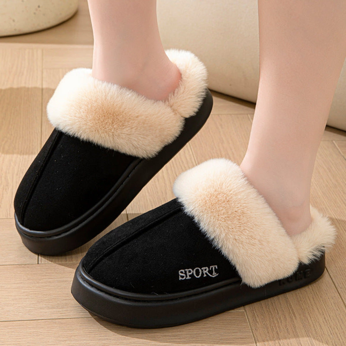 Black cozy faux suede house slippers shown from the side