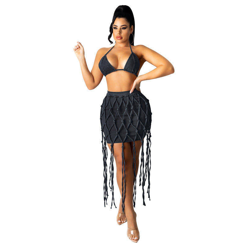 Woman wearing high-waist dark blue denim woven mini skirt with long fringe detailing.