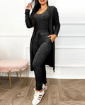 Brielle women's charcoal black coordinated jumpsuit and cardigan set shown full length, featuring a scoop-neck fitted jumpsuit with drawstring waist detailing and a matching long open-front cardigan styled with casual fashion sneakers.