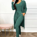 Brielle women's green coordinated outfit shown from the front, featuring a sleeveless scoop-neck jumpsuit with a fitted silhouette, drawstring waist styling, tapered pant legs, and a matching long open-front cardigan with sleeves.