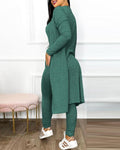 Brielle women's green knit-look jumpsuit and long cardigan set shown in a side and back view, featuring a fitted sleeveless scoop-neck jumpsuit with slim tapered pants, a coordinating open-front long-sleeve cardigan extending below the hips, soft-looking textured fabric, and white athletic sneakers.