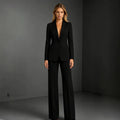 Camille women's black tailored pants suit displayed on a model, featuring a long-sleeve blazer with a classic notched collar and coordinating black wide-leg dress trousers for a sophisticated professional outfit.