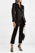 Black Celeste Lace Pointed-Toe Stiletto Pumps styled with cropped black trousers and a blazer, featuring sheer black lace-pattern detailing, pointed toes, slim high heels, and delicate ankle straps.