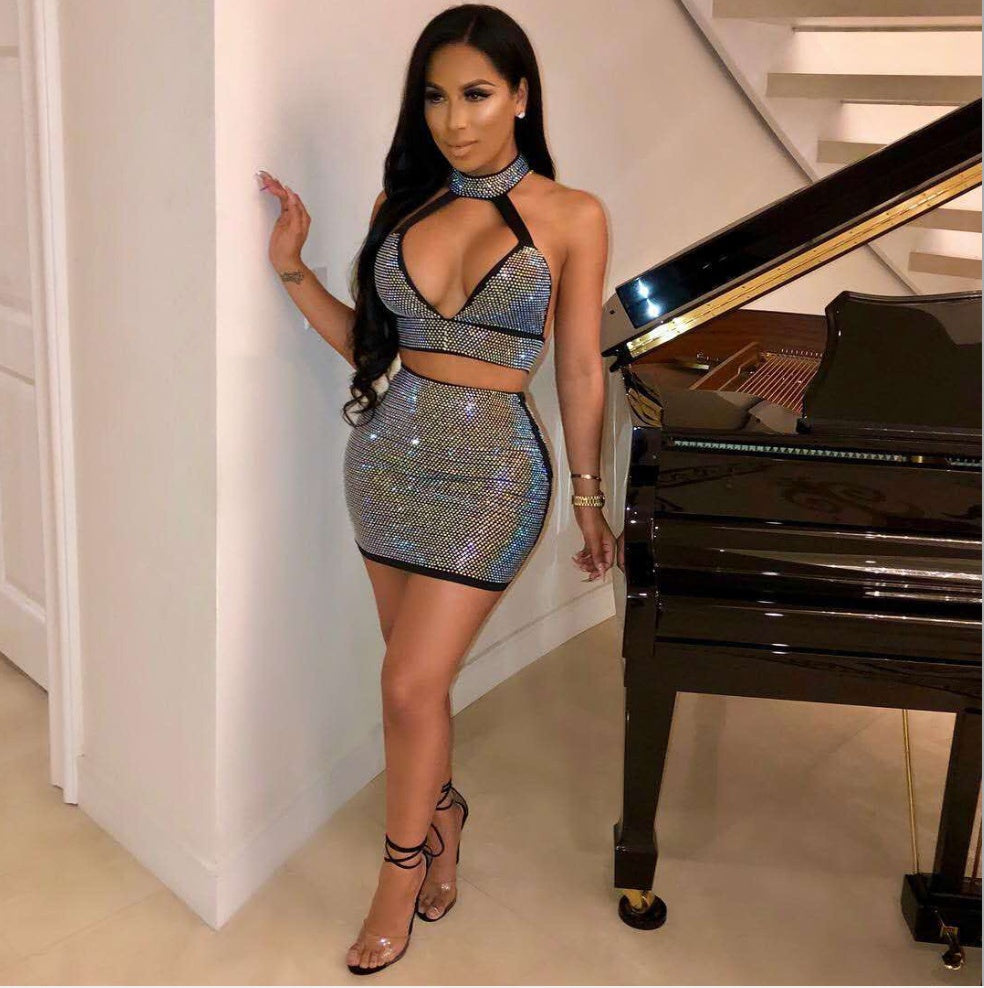 Woman wearing crystal rhinestone halter crop top and matching fitted mini skirt.