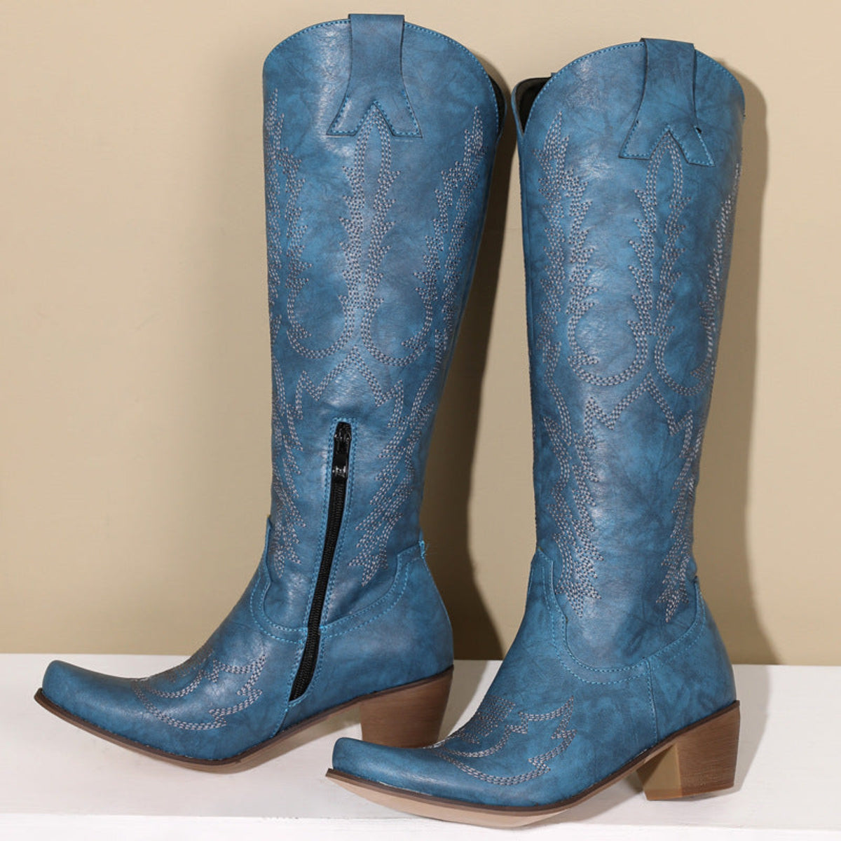 Women’s blue Dakota embroidered Western knee-high boots featuring intricate tonal Western stitching, pointed toes, tall structured shafts, and comfortable low block heels displayed together against a neutral background.