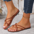 Dark brown braided toe-ring flat sandals for women shown worn on both feet, featuring slim woven crossover straps, open toes, low flat soles, brown footbeds, and visible contrast stitching, styled with cropped distressed denim for a casual summer look.