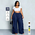 Delilah women's dark blue wide-leg cargo pants displayed from the front, showing the high-waisted gathered waistband, adjustable center drawstring, voluminous fabric through the legs, oversized utility-style pockets, and decorative gathered detailing extending toward the ankles.