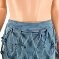 Close-up of woven denim detailing on women's high-waist mini skirt.