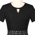 Close-up of black fit and flare dress showing the keyhole neckline, short sleeves, and decorative lace waist detail.