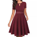 Burgundy lace-waist fit and flare dress with short sleeves, keyhole neckline, and flared knee-length skirt.