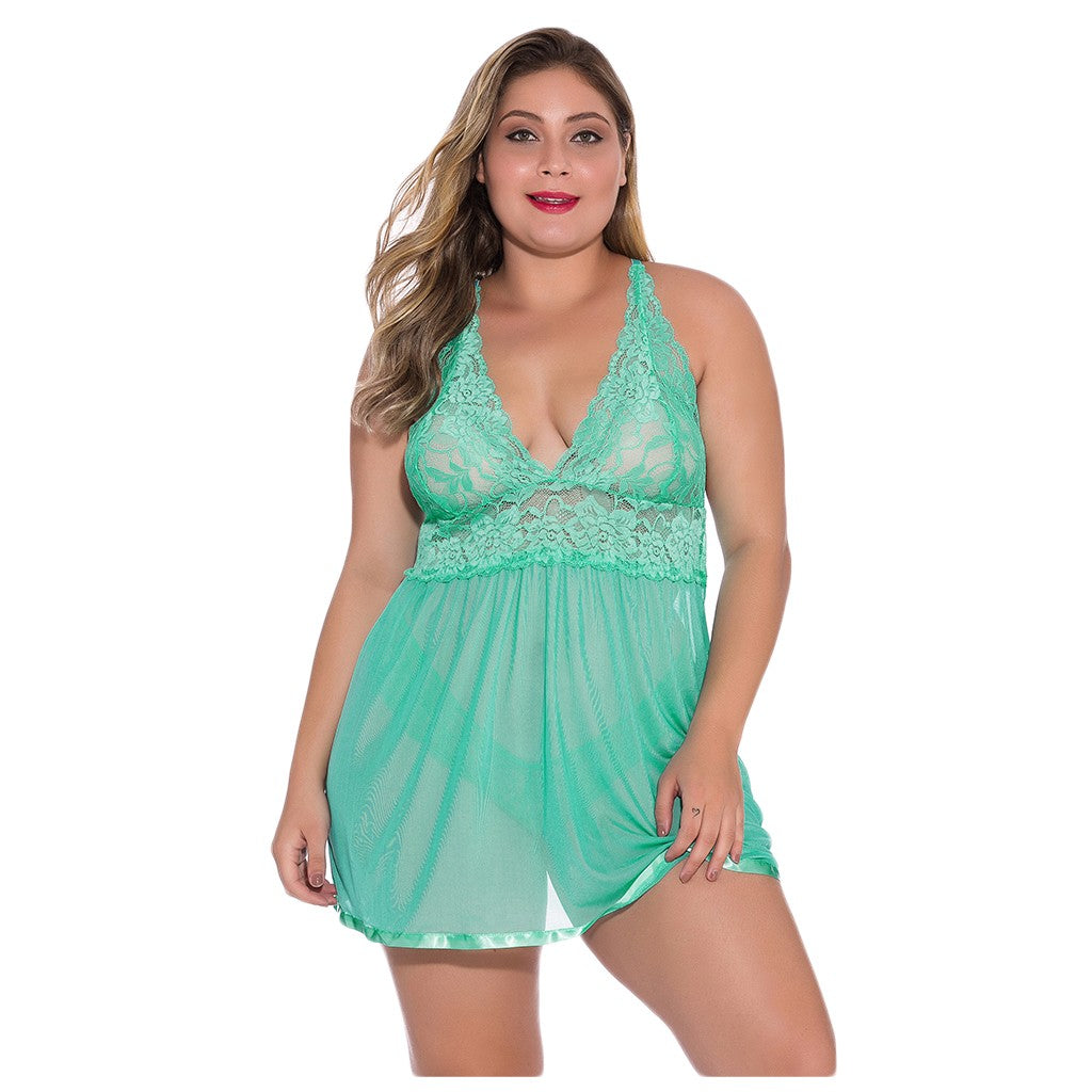 Front view of the Eliana green plus-size lace babydoll nightdress worn by a brunette model, featuring mint-colored floral lace along the deep V-shaped neckline, slender shoulder straps, a fitted lace bodice, and a lightweight-looking sheer green mesh skirt with a softly flowing hem.