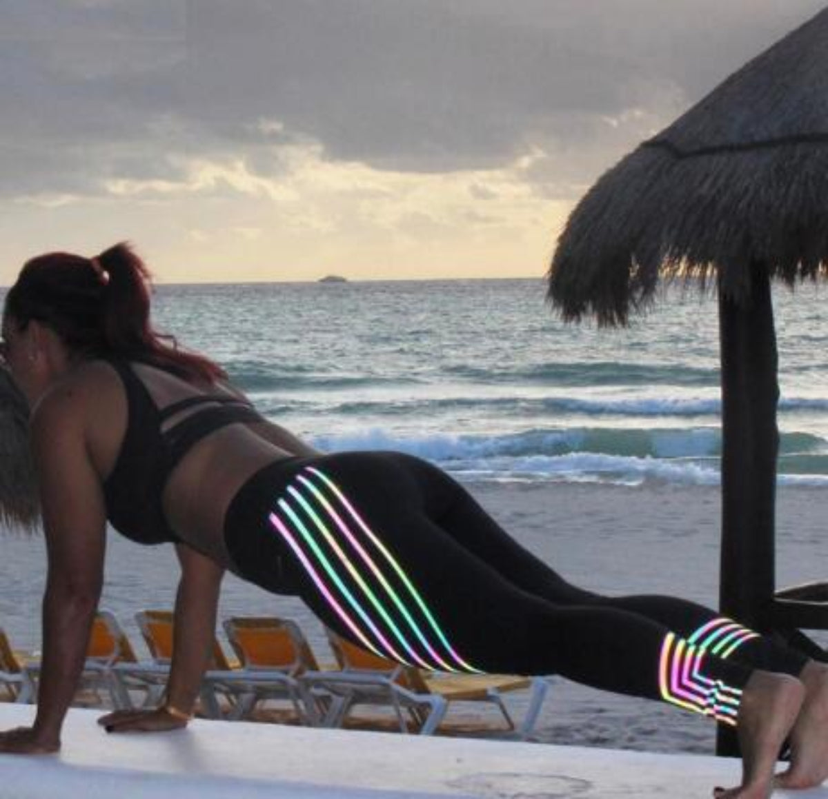 Black Everyday Sculpt women’s high-waist leggings with multicolor striped side detail shown in an outdoor action pose