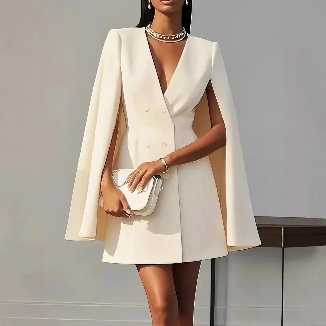 Apricot double-breasted cape blazer dress with V-neckline, tailored waist, and cape sleeves.