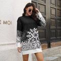 Woman wearing a Black long-sleeve Christmas sweater dress with a large white snowflake pattern while standing outdoors in front of a dark wooden doorway.