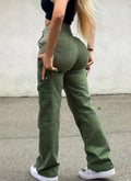 Women's green high-waist stretch cargo pants with utility pockets, back view