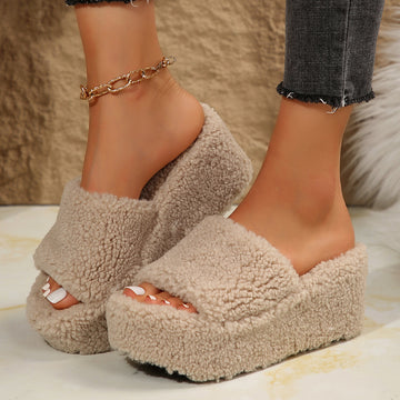 Khaki fleece-lined platform house slippers worn by a woman