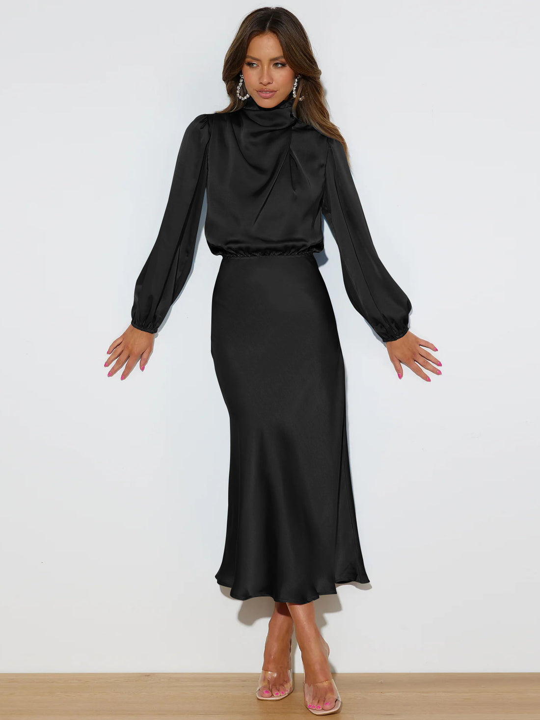 Emerald green draped satin maxi dress with long sleeves, high neckline, and flowing skirt.