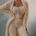 Naomi women's beige three-piece matching outfit modeled from a three-quarter front view, featuring a fitted square-neck crop top with a center drawstring tie, long-sleeve open-front cardigan with contrast trim detailing, and coordinating high-waisted fitted pants with a textured ribbed finish.