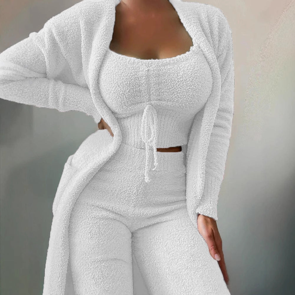 Naomi women's white three-piece matching pants set shown from a three-quarter front view, featuring a fitted square-neck crop top with a decorative center drawstring, coordinating long-sleeve open-front cardigan with curved trim detailing, and high-waisted fitted pants in textured white ribbed fabric.