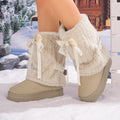 Women’s beige Noelle Bow platform snow boots side view featuring soft plush fleece material, oversized beige ribbon bows, ankle strap detailing, rounded toes, and thick neutral-colored platform soles.