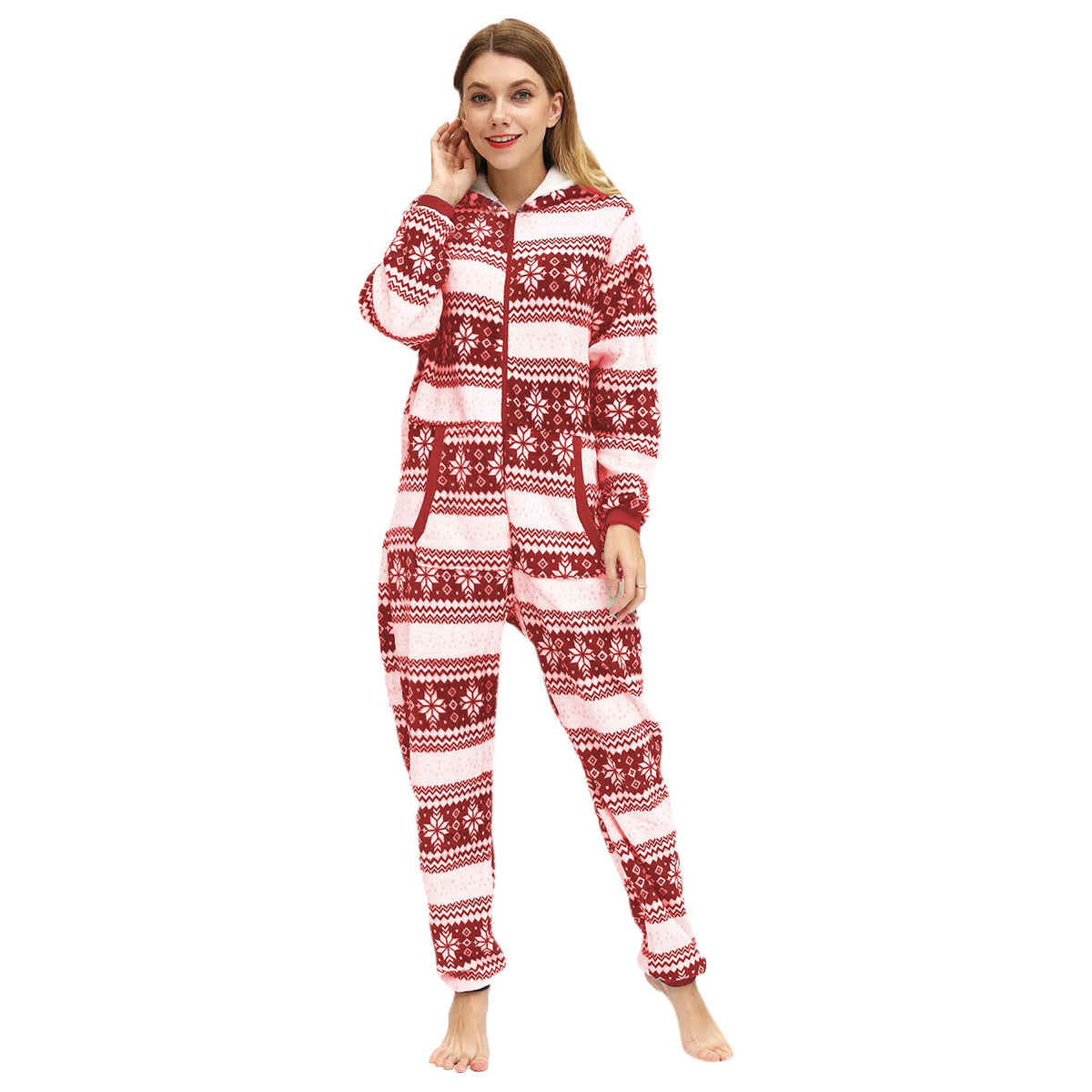 Front view of the Noelle red and white holiday pajama onesie highlighting the attached hood with white drawstrings, front zipper closure, repeating red snowflake and reindeer patterns, and long sleeves finished with contrasting red ribbed cuffs.