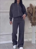 Model showcasing a black tracksuit with a zip-up jacket and wide-leg pants