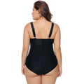 Rear view of the Sasha women's black one-piece swimsuit displayed on a model, highlighting the open-back construction, narrow black shoulder straps, and smooth solid black lower portion of the swimsuit.