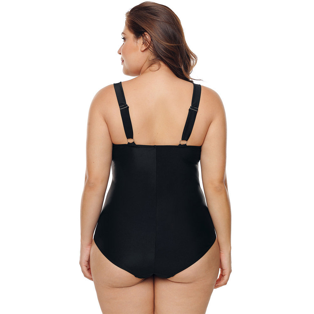 Rear view of the Sasha women's black one-piece swimsuit displayed on a model, highlighting the open-back construction, narrow black shoulder straps, and smooth solid black lower portion of the swimsuit.