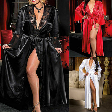 Collage showcasing the Seraphina women's luxe satin-look long robe in classic black, red, and white, modeled by three women in elegant indoor settings. The black robe features a deep V-neckline with intricate floral lace trim, long flowing sleeves, a matching waist sash, and a dramatic floor-length open-front silhouette. The ruby red version highlights its glossy satin-look fabric and coordinating belt, while the ivory white robe features delicate lace detailing along the neckline and a softly draped skirt.