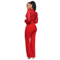 Seraphina women's vibrant red lace evening jumpsuit modeled in a three-quarter side and back pose, featuring a high lace neckline, fitted waist, long sheer red sleeves with gathered cuffs, decorative lace detailing, and matching full-length red trousers.