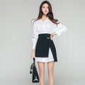 Woman wearing white long-sleeve shirt and high-waist black asymmetrical skirt set.