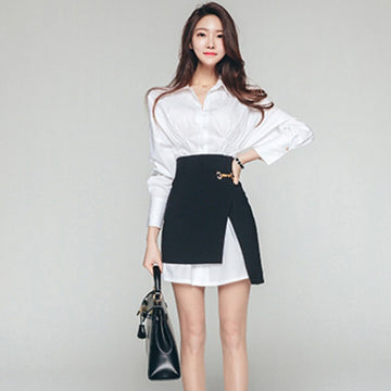 Woman wearing white long-sleeve shirt and high-waist black asymmetrical skirt set.