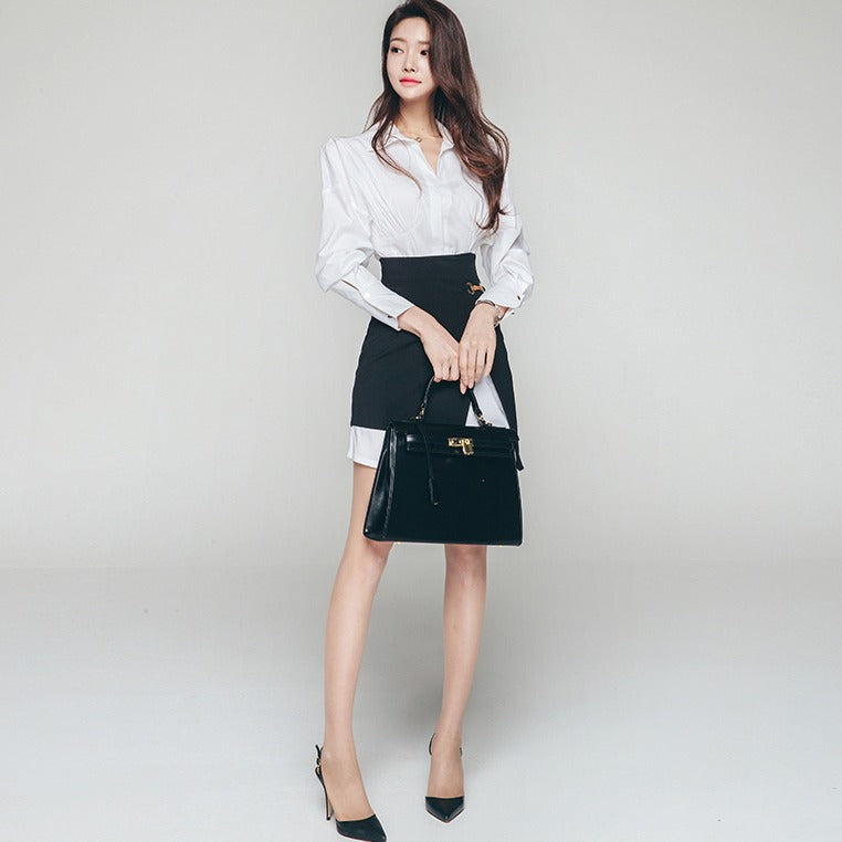 Full-length view of women's white shirt and black asymmetrical skirt outfit.