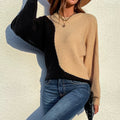 Woman modeling black and camel color-block knit sweater with long sleeves and relaxed fit