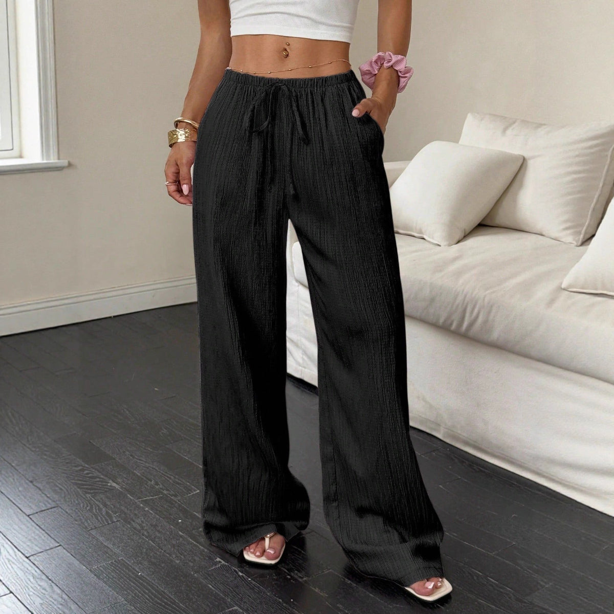 Women's black high-waist drawstring wide-leg pants with textured fabric and side pockets