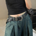 Women’s black Western-style belt with ornate silver-tone buckle styled with loose blue denim jeans