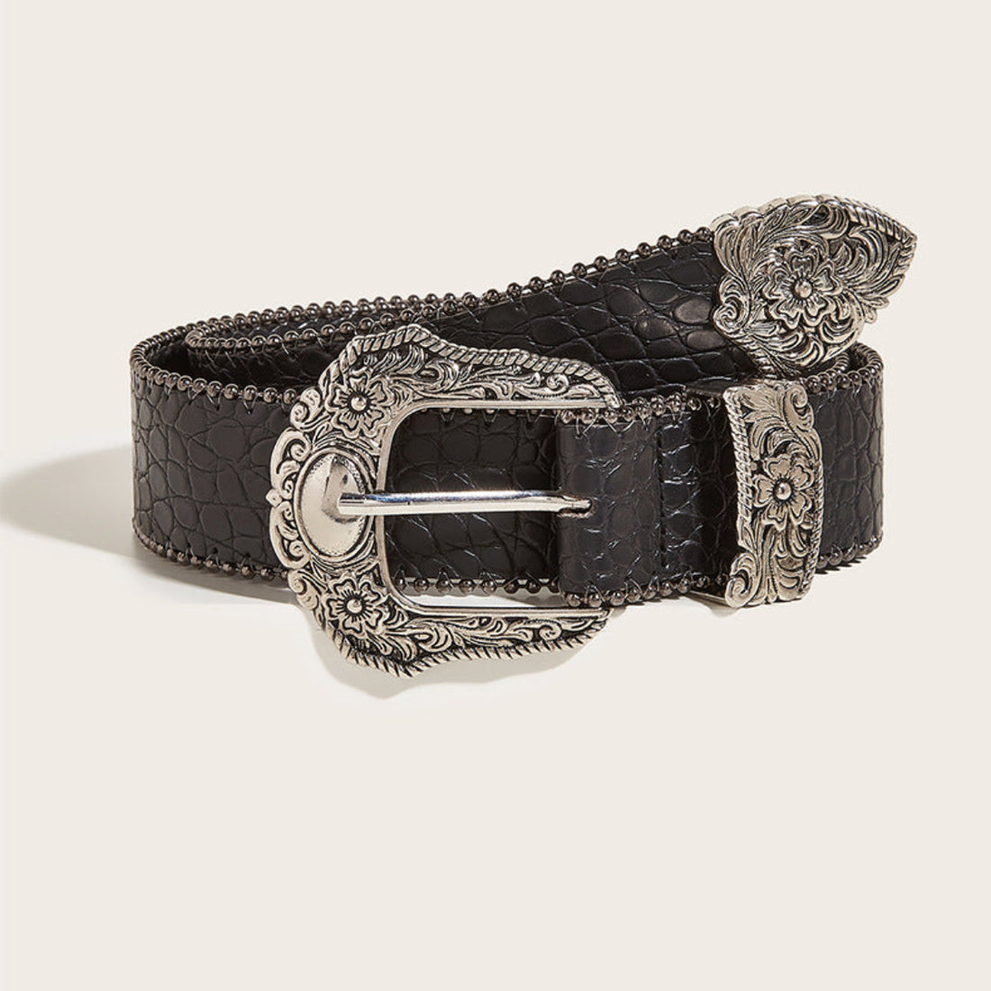 Women’s black Western belt with ornate silver-tone floral buckle and textured finish shown rolled