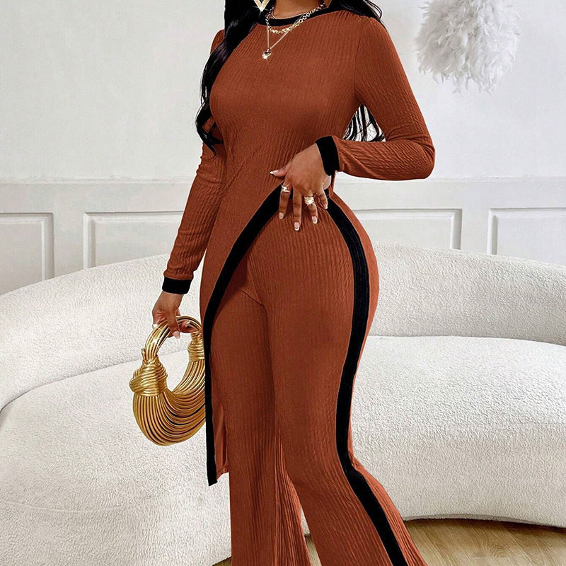 Woman wearing a apricot outfit with black accents, holding a gold handbag in a room.