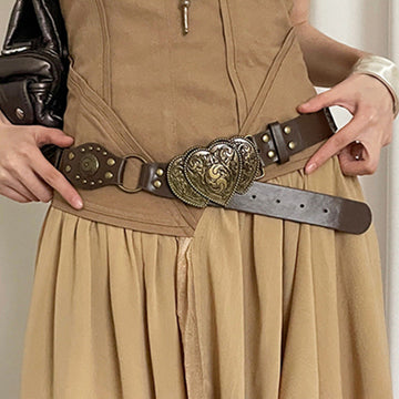 Women’s brown Western-style belt with ornate antique-tone heart buckle styled over a tan outfit