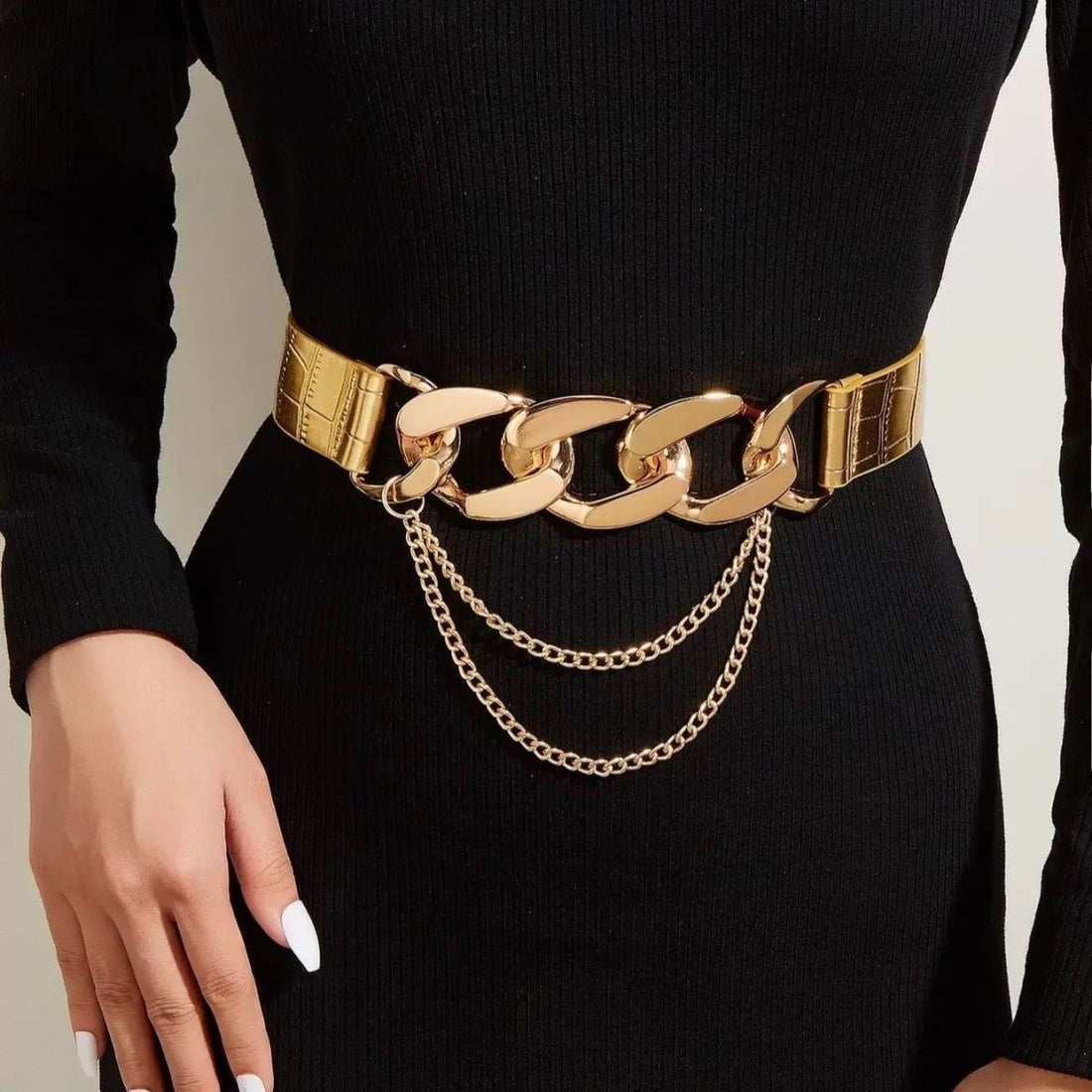 Women’s gold chain elastic waist belt styled over a fitted black dress