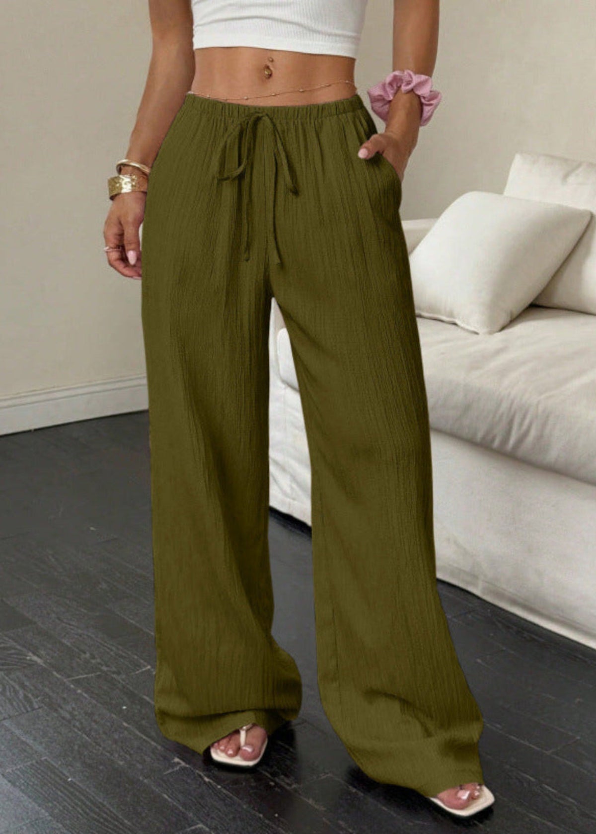 Women's olive green high-waist drawstring wide-leg pants with textured fabric and side pockets