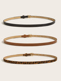 Women’s skinny gold buckle belts in black, cognac brown, and leopard print shown in side profile